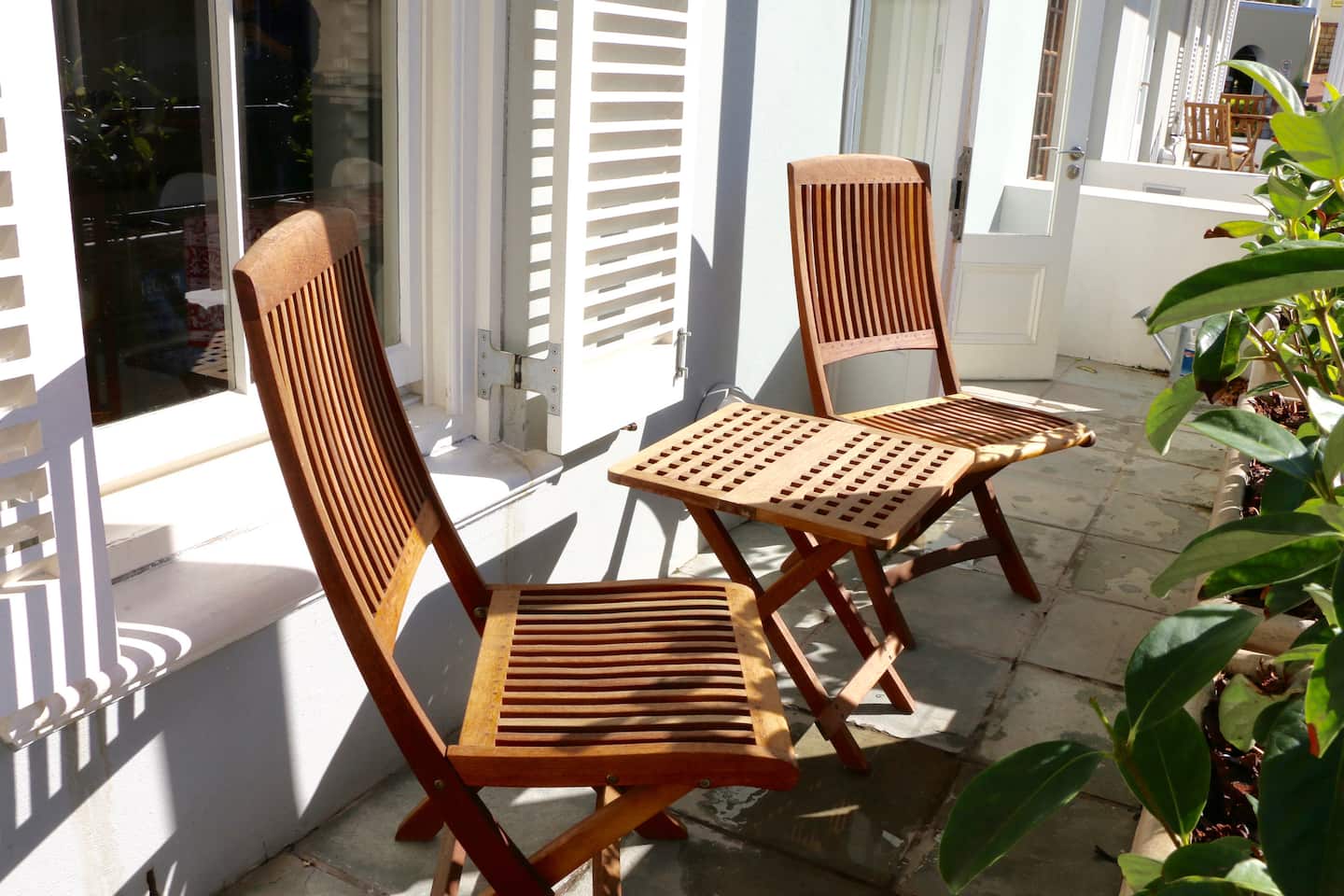 Sunny balcony with wooden chairs at The Majestic Apartment, Kalk Bay